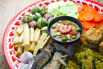 Shrimp - paste sauce with vegetables, omelet, fried mackerel  on wooden table.