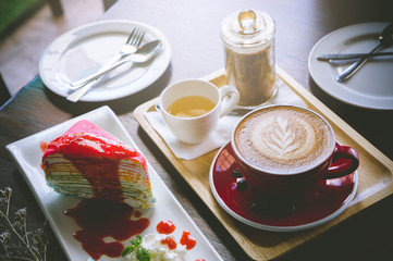aroma coffee red cup latte art and tasty cake on wood table in coffee shop with vintage dark tone and copy space