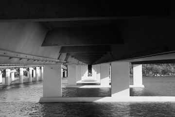 Obraz premium Under concrete bridge across river black and white