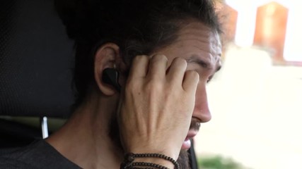 Man driving a car at countryside and using hands free device to make a call