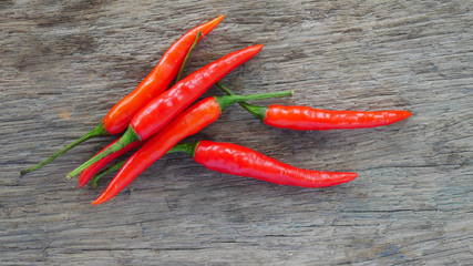 Fresh red chili on wood texture.