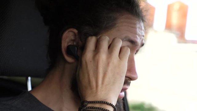 Man driving a car at countryside and using hands free device to make a call