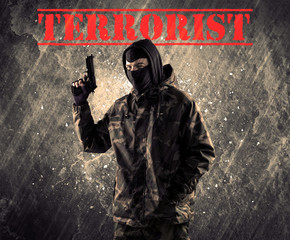 Dangerous masked and armed man with terrorist sign on grungy background
