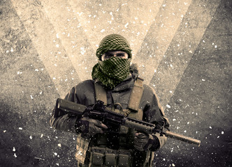 Portrait of a dangerous masked armed soldier with grungy background