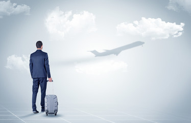 Obraz premium Businessman with luggage look to an airplane