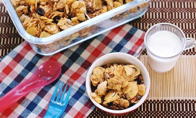  Morning breakfast. Cornflakes cereal in a red bowl with milk 