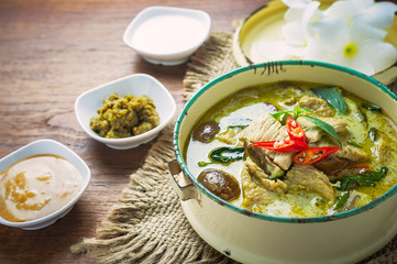 Thai food green curry chicken on wooden background.