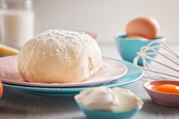 Baking ingredients and dough on wooden background