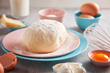 Baking ingredients and dough on wooden background