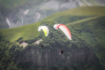 Paragliders in flight in the mountainous region of Georgia.