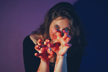 girl with scary make up on Halloween party. focus on bloody hands.