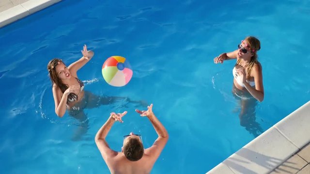 Friends playing ball games in pool