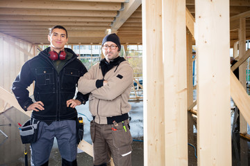 Confident Carpenters Standing At Construction Site