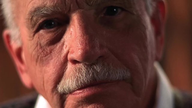 Closeup of serious elderly white man with mustache.
