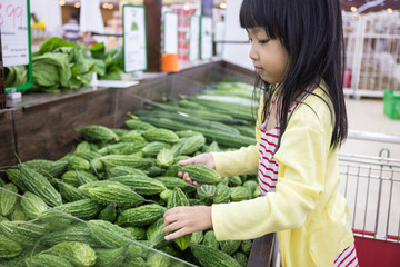 Asian Little Chinese Girl choosing vegetables