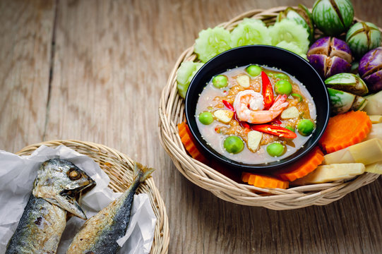 Shrimp - paste sauce with vegetables, omelet, fried mackerel  on wooden table.
