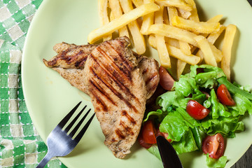 Grilled chicken breasts served with fries