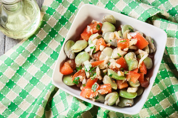 Broad bean salad with tomatoes, onion and olive