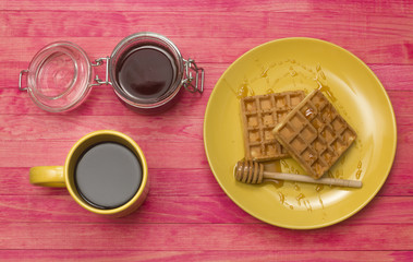 Viennese waffles with mug coffee and jar honey