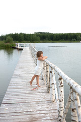 Fototapeta na wymiar girl child on bridge on lake,childhood, light tone