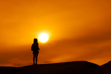 Young girl asian with backpack travel trip stand finish destinations on the mountain looking view sunset silhouette