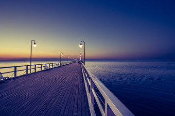 Fototapeta premium Amazing sunrise on the pier at the seaside. Gdynia Orlowo, Poland