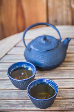 Traditional japanese green tea prepared in cast iron teapot with organic dry green tea.