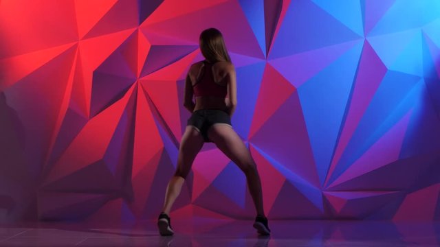 Booty danse with girl in shorts on bright graphic background