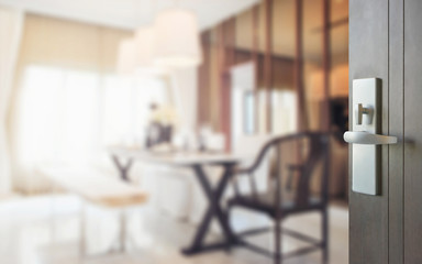 opened wooden door to modern dining room interior.