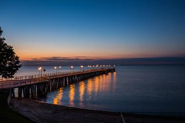 Obraz na płótnie Canvas Amazing sunrise on the pier at the seaside. Gdynia Orlowo, Poland