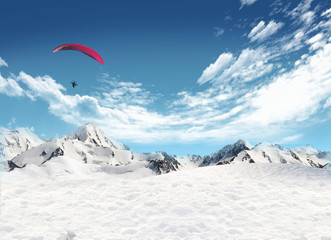 Mountain landscape with snow and man flying in the sky