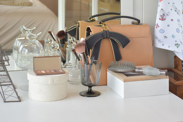 Make up items and leather bag on dressing table