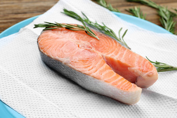 Fresh salmon steak with rosemary on paper towel