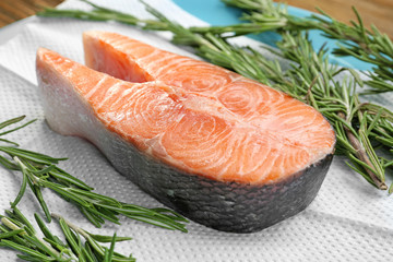 Fresh salmon steak with rosemary on paper towel