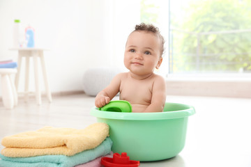 Little baby washing in bath basin at home