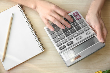 Young woman calculating calories at table. Weight loss concept