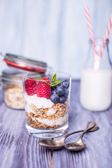 yogurt with muesli and berries on a wooden table