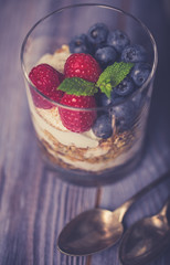 yogurt with muesli and berries on a wooden table