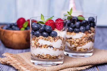 yogurt with muesli and berries on a wooden table