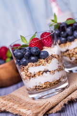 yogurt with muesli and berries on a wooden table