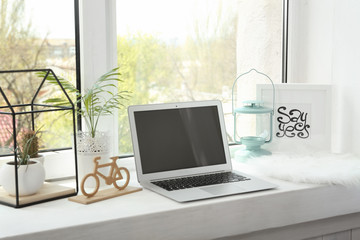 Modern comfortable workplace with laptop on window sill at home