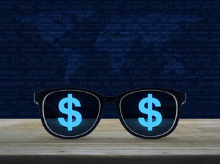 Dollar currency icon with eye glasses on wooden table over world map and computer binary code blue background, Business vision concept, Elements of this image furnished by NASA