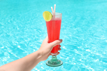 Hand of woman with glass of cocktail at resort