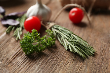 Composition with fresh herbs and vegetables on wooden background