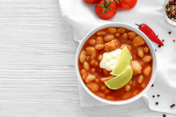 Composition with delicious turkey chili in bowl on wooden table
