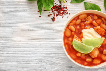 Delicious turkey chili in bowl on wooden table