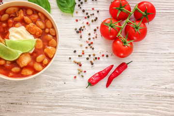 Composition with delicious turkey chili in bowl on wooden table