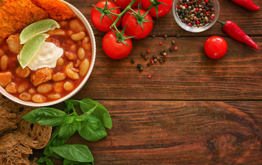 Composition with delicious turkey chili in bowl on wooden table