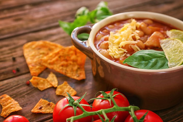 Delicious turkey chili in casserole on wooden table