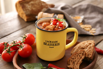 Mug with delicious turkey chili on wooden table